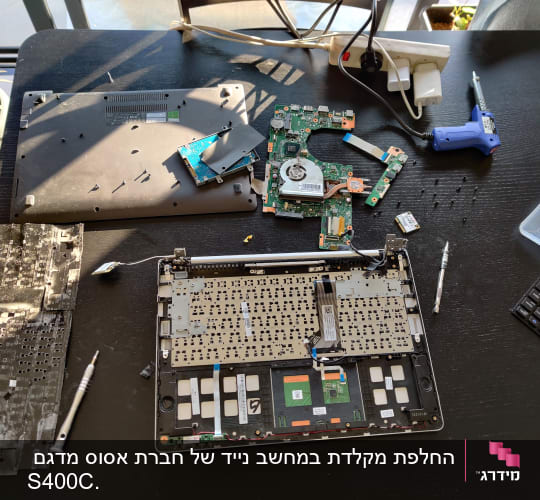 חלקי מחשב נייד מפורקים על שולחן עבודה